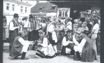 Czarno-białe zdjęcie przedstawiające śpiewaków ludowych i uczestników Festiwalu Kapel Ludowych w Kazimierzu w 1972 roku.