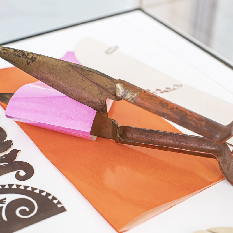 Zdjęcie pokazuje duże, stare nożyce służące do cięcia papieru.