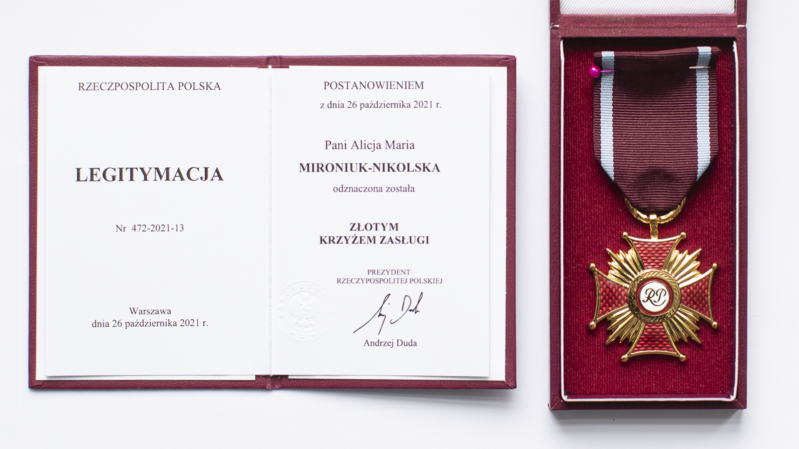 Zdjęcie Złotego Krzyża Zasługi w pudełku oraz legitymacji wręczonej przez Prezydenta Rzeczypospolitej Polski Andrzeja Dudy